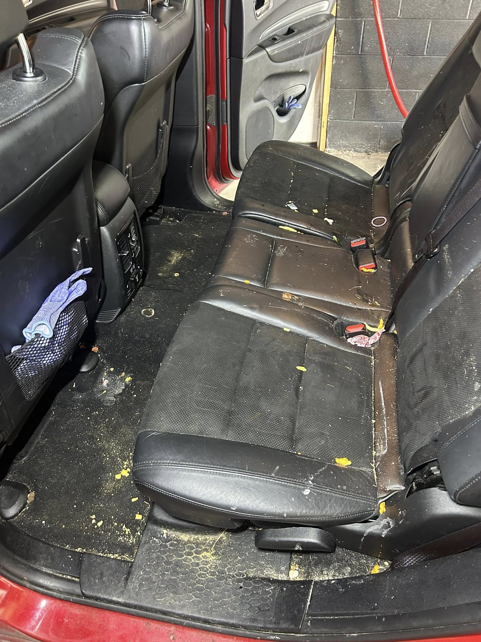 Red car interior before cleaning - dirty rear seats