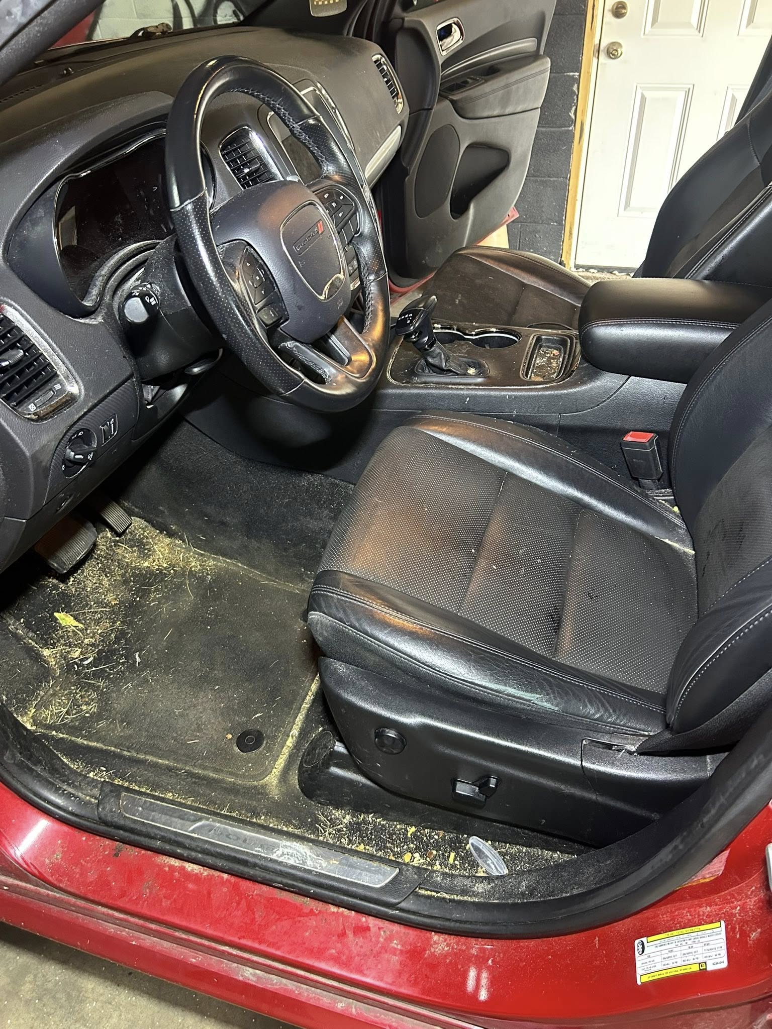 Red car interior before cleaning - dirty driver's side