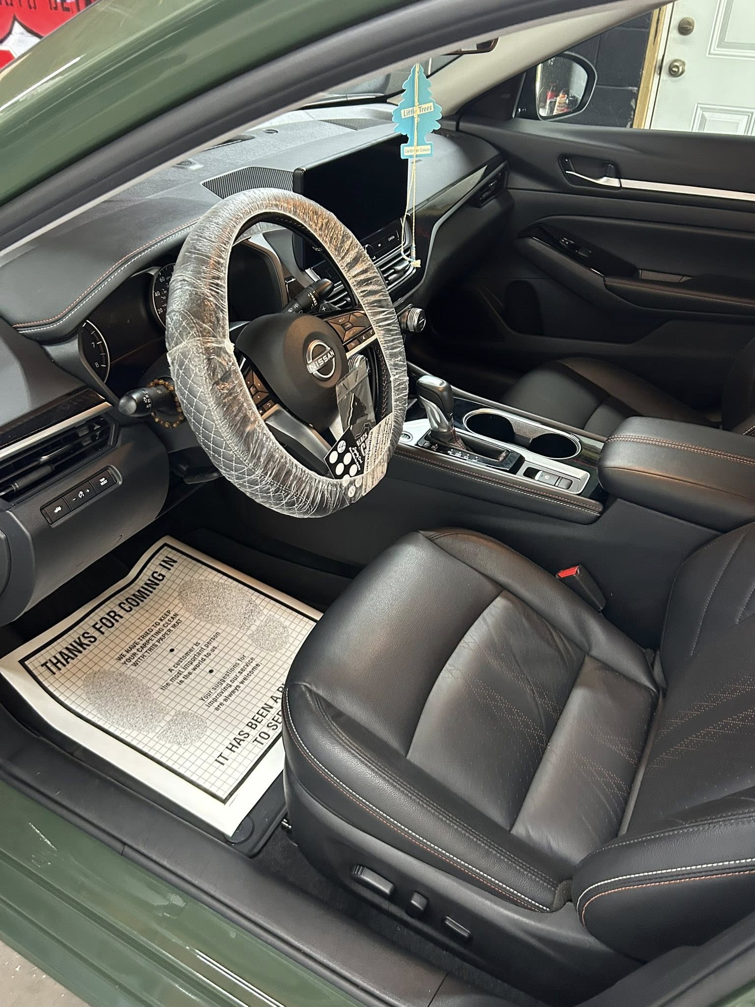 Clean Nissan Altima driver's seat and dashboard